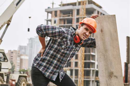 Construction worker with hurt back who needs an Attleboro workers' compensation lawyer