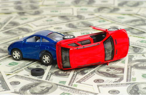 Toy cars crashed on top of money, Pembroke car accident lawyer concept